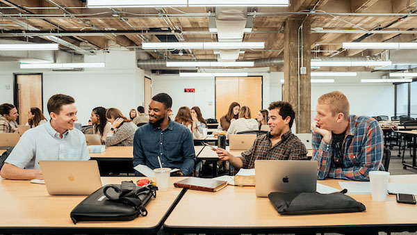 Male students sitting at classroom desks in the Watermark Institute teaching session.